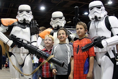 Cosplayers dressed as Star Wars stormtroopers posed with children at Arizona Comic Con in 2015.