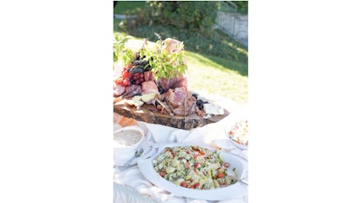An outdoor cocktail reception with a charcuterie sample