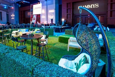 Design Foundry created an indoor garden with two-foot hedges and faux grass turf in front of the dance floor. Hanging wicker chairs and a mix of hightop wooden stools and white canvas lounge furniture provided seating.