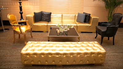 Gold metallic straight modular sofa paired with gold and black Chateau chairs.
