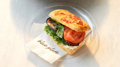 Grilled eggplant sandwich with whipped goat cheese and oven-cured plum tomatoes on tomato focaccia.