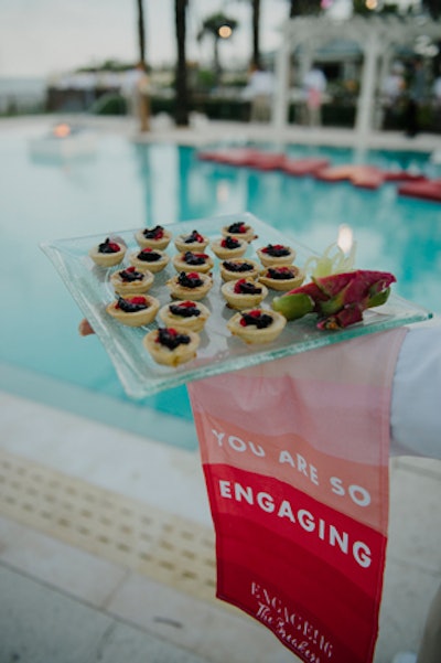 Branded towels were draped over the waiters' arms during the pool party.