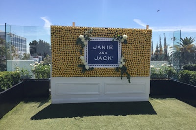 In keeping with the moulding-trimmed look of the pop-up shop, a press wall appeared more like a piece of furniture than a temporary photo backdrop. Decorated with lemons for an eye-catching yellow look, the wall also featured logo signage in the brand's signature blue color, as well as white florals and trailing greenery.