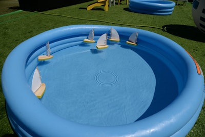 Toy sailboats—in the event's signature colors of yellow and white—bobbed in wading pools for fun and heat relief.