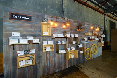 Without the need for bidding sheets, Design Foundry could display the local dining gift certificates and plaques on a mixture of shelves and crates attached to one of the gallery walls. This provided a better vantage point for multiple guests to view the items at once, like in a museum, compared to a table arrangement where only one guest can view an item at a time.