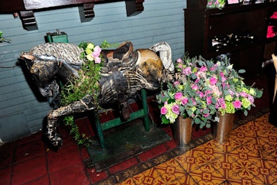 Flowers in metallic vessels also decorated a vintage carousel horse within the space. Flowers and vines trailed from its neck as well.