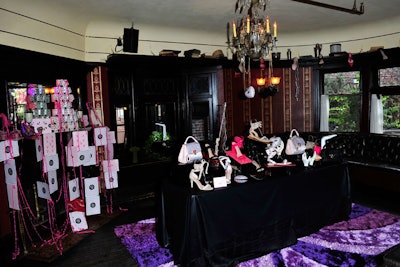 Product displays on black draping popped atop a sumptuous purple patterned carpet.