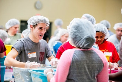 Feeding Children Everywhere assembles groups to package healthy meals for children in need.