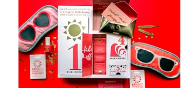 Advent-style pre-arrival mailer filled with branded travel accessories, including sleep masks and sunscreen.