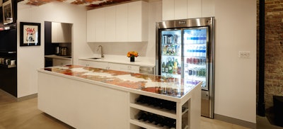 A full view of the kitchen with a fully stocked beverage fridge