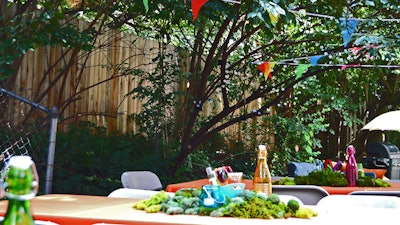 Tables were set with fluffy moss and summer necessities like sunscreen, bug spray, and sunglasses.