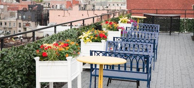 Comfy bench seating and ivy-covered trellises create a garden party feel.