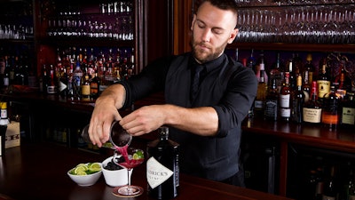 Head bartender Andrzej Zabicki pouring an original cocktail