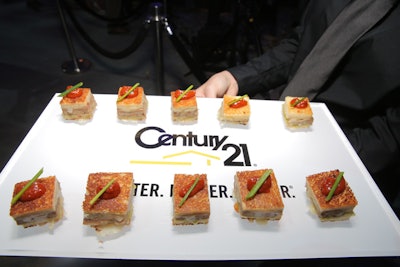 Servers offered mini turkey burger sliders with pepper jack cheese, cilantro aioli, and tomato chutney from trays with the company's logo.