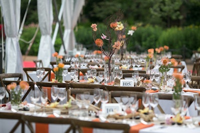 In the clear dinner tent, decor comprised natural elements such as twisted branches and wildflowers; the color palette was inspired by the hues of an African sunset.