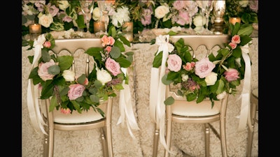Elegant floral garlands are a modern way to designate bride and groom chairs.