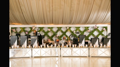 Stage design, drape, and a floral wall for a lush wedding.