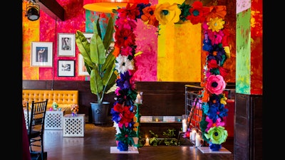 Quite the entrance with a colorful, jumbo paper flower arch.