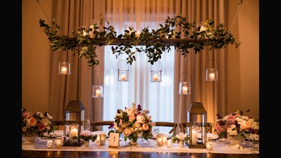 Suspended leaf greenery above a vintage tablescape.