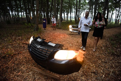 The foundation’s ”As We Lay Dying: She Would Come Up With Reasons' had guests meander through a field of amputated car headlights that were oscillating back and forth. Lined up facing guests and the 'One Ton Tank' installation, different models of skeleton-like cars blocked the pathway and shone through the trees at dusk.