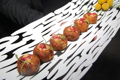 At a Los Angeles event hosted by Century 21 Real Estate in July with a futuristic look and feel, hors d’oeuvres—such as lump crab cakes with remoulade and micro arugula—were served on modern-style white platters that included unusual cutout forms.