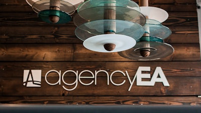 The AgencyEA logo is displayed in the office.