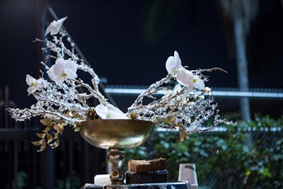 Shawna Yamamoto Event Design filled large metallic bowls with snow-dusted branches, gold-foiled greenery, and white orchids for the corporate holiday party last year at the Natural History Museum in Los Angeles.
