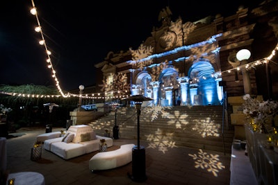 For the corporate holiday party at the Natural History Museum in Los Angeles, event design and production company Sterling Engagements created an outdoor winter wonderland with string lights and snowflake projections.
