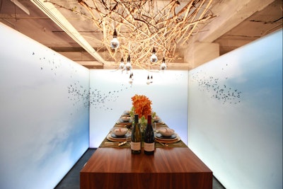 A table at Diffa Dining by Design in Chicago in 2013 had a canopy of twigs and a wraparound scene of birds flying in a blue sky, giving the vignette a calming vibe.