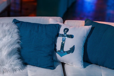 Blue and white throw pillows, some emblazoned with sequin anchors, contributed to the nautical theme.