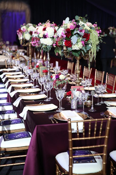 Regal rose arrangements towered over opulent tabletops.