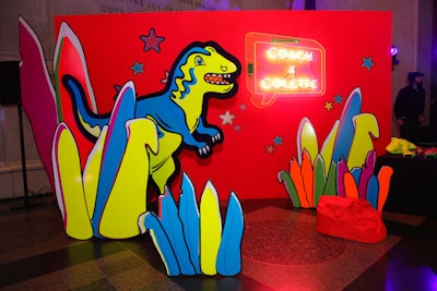 An oversize dinosaur prop and coordinating set pieces decorated a photo booth for Coach.