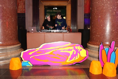 A colorful, graphic scene decorated the DJ booth, suggesting a cartoonish representation of a prehistoric landscape.