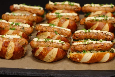 Smoked chicken sausage, served on a pretzel roll with caramelized onions, apples, kale, fennel, and cabbage and topped with an aioli made of Brooklyn Lager, mustard seed, and caraway, by Abigail Kirsch in New York