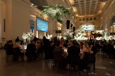 The museum broadcast the Cubs game during cocktails and dinner by projecting it onto screens in Stanley Hall. HMR Designs filled the room with lush, white floral arrangements.