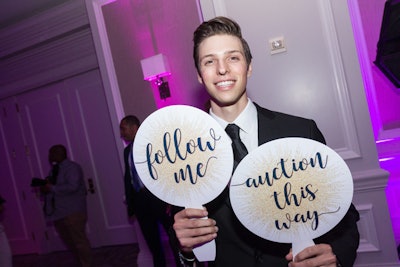 Staffers with handheld signs wandered through the reception area directing guests to the silent-auction room located down the hallway from the main event space.