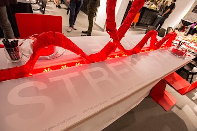 The Ruder Group's table, designed by Nelson, reminded guests of the event's cause. On either side of the table letters spelled out 'Strength' and 'Courage.' A design in the shape of the red ribbon that symbolizes AIDS awareness ran down the center of the table.