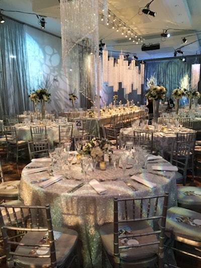 The design for the dinner space centered around white with accents of silver in the chairs, linen overlays, centerpiece vases, chargers, and stemware to create an ambience of the snowy Swiss Alps.