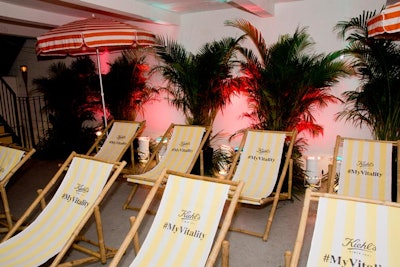 The seating area included branded striped beach chairs, umbrellas, and palm trees.