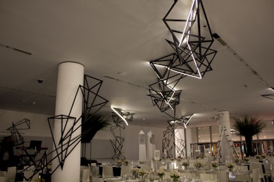 At its seventh annual film benefit in 2014, the Museum of Modern Art honored writer and director Alfonso Cuarón. The Academy Award-winning director's movie Gravity served as a design inspiration for the event’s interpretive design: Suspended from the ceiling of the museum’s lobby hung large metal sculptures trimmed with LED lights. The effect was dramatic, although the decor pieces took simple geometric forms in only black and white.