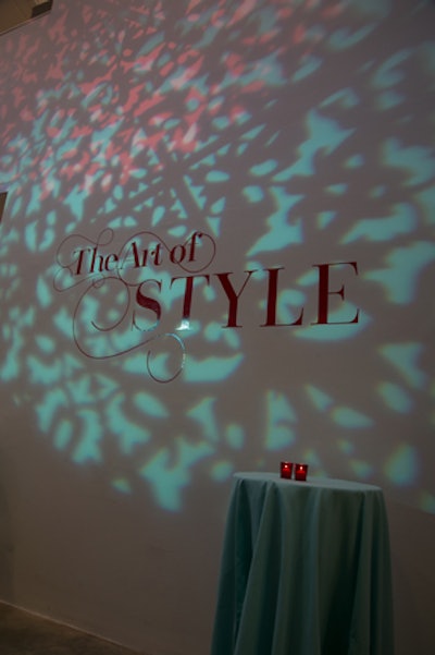 A mix of blue and red patterned projection lighting highlighted the event theme on the three-story white wall inside the entrance to the exhibit area.