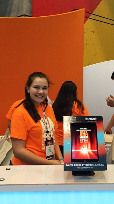 Happy event staff behind the custom branded self check-in kiosk