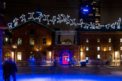 The installation 'Run Beyond,' by Angelo Bonello of Italy, features 18 LED characters across two buildings.