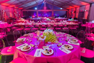 The event had a hot-pink color scheme with table linens and seat cushions.