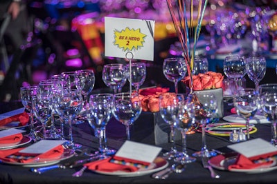 After the cocktail reception and silent auction, guests headed across the street for a three-course dinner catered by Occasions Caterers in the school's gym, where the red, blue, yellow, and black hero-theme decor continued.