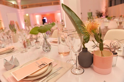 On tabletops, single stems and leaves filled varying vessels in gray and pink hues, as well as clear glass.