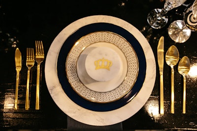 Elegant, gilded plateware, glassware, and flatware suggesting royalty came from Town & Country Event Rentals.