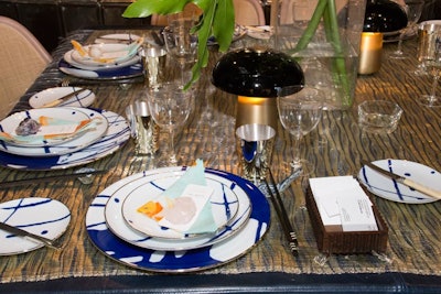 The tabletop featured Tzelan plates that depict the movement of the sea atop hand-woven metal tablecloths made by French artisans. The mushroom lamps, which are a Tzelan and Contardi collaboration, are portable and come in nine metal finishes.