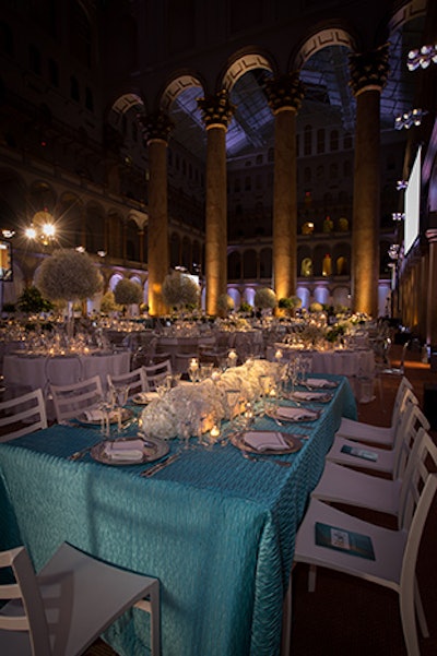Tutera used light blue linens, evocative of the night's printed program, in one of the four table designs with all white hydrangeas and candles at the center.