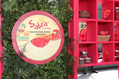 The garden walls were themed around different flavors of Sabra hummus. The brand's roasted red pepper wall included a giant replica of the container found in stores, alongside a red shelf that featured fresh red peppers, peppers in jars, and wooden bowls.